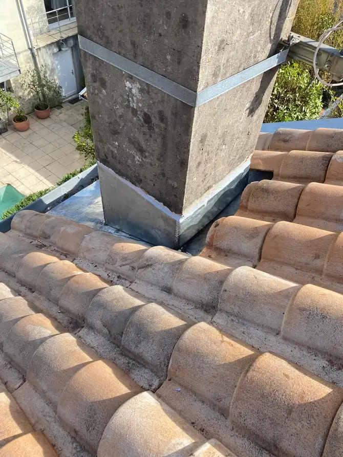 Souche de cheminée et son solin sur une toiture en tuiles